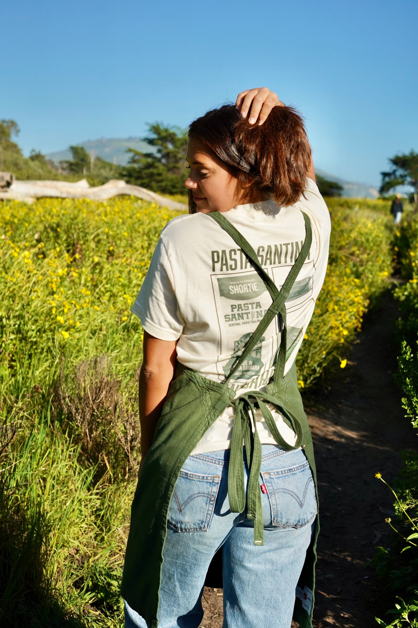 Photo of model in green crossback apron (back)