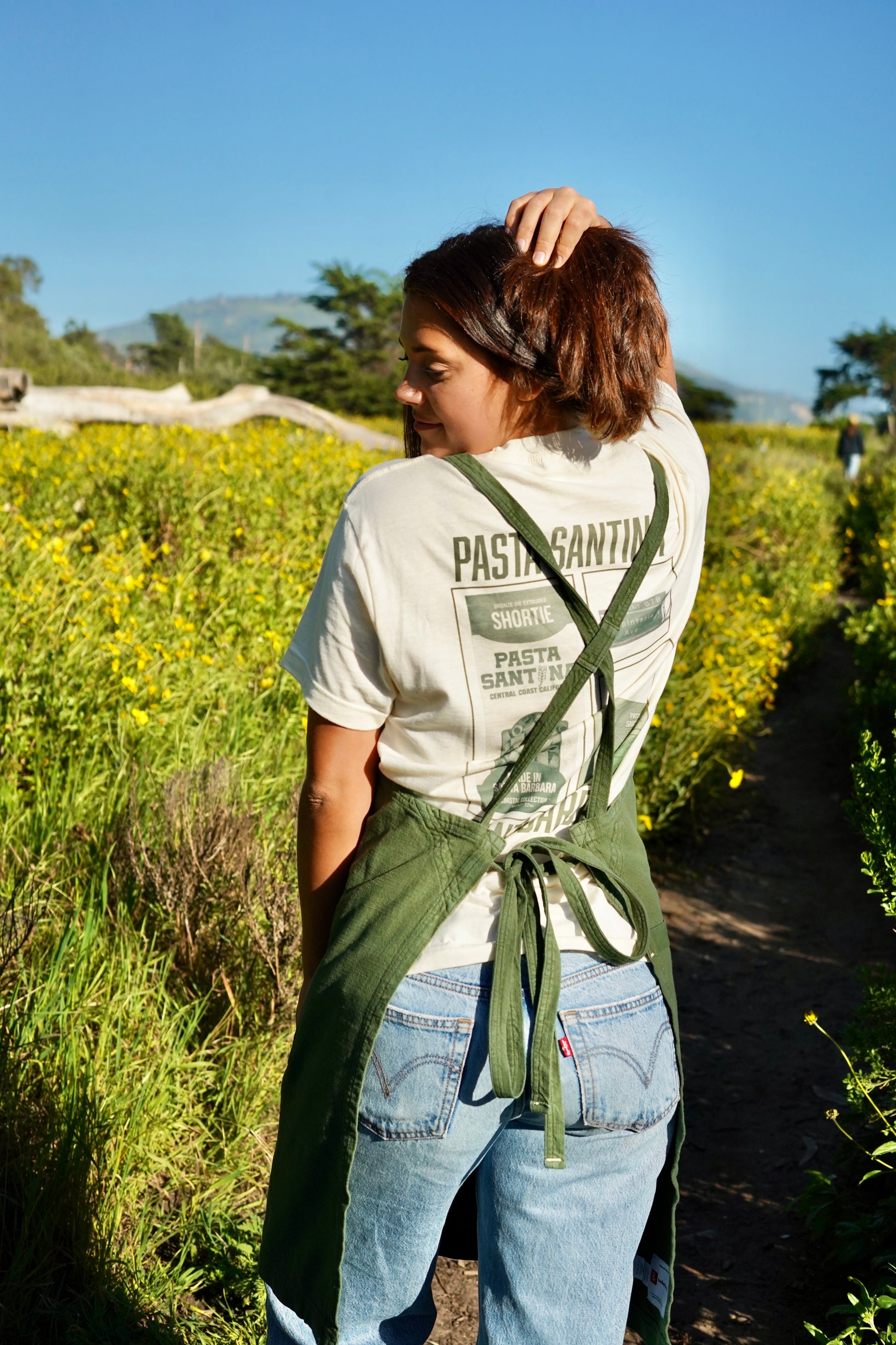 Photo of model in green crossback apron (back)